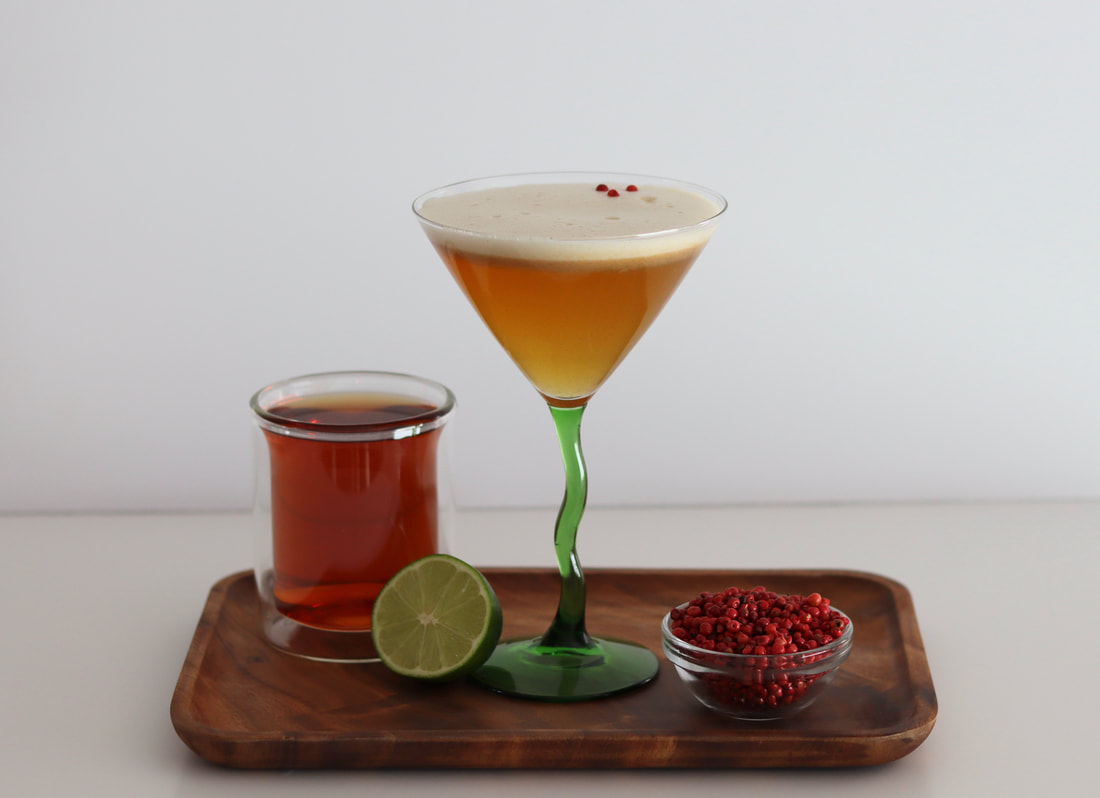 Non-alcoholic tea martini mocktail with tea and pink peppercorns